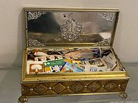 Overall view of open metal box showing stamps inside