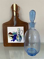 Enesco cheese board with knife and blue glass decanter group shot