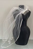 Veil displayed on dress form showing overall drape and comb attachment