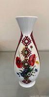 Full view of porcelain vase front showing floral decoration and red geometric band