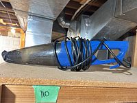 Side view of blue handheld vacuum with cord wrapped around body
