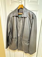 Front view of black leather jacket with pockets and collar