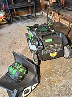 Top view of folded EGO mower with battery and grass bag visible
