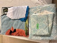 Folded fleece throw, paisley quilt, tie-on sham, bed skirt stacked on bed