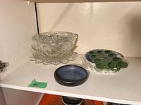 Glass punch bowl on matching underplate beside snowman plate and blue bowl