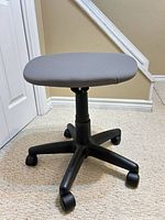 Stool side view showing seat, adjustable column, five-star caster base