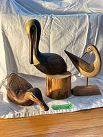 All three wooden bird sculptures grouped together