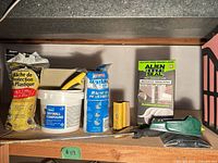 Shelf view showing drywall compound, plastic sheeting, Alien Draft Seal box, scraper, sanding block