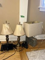 Two brass lamps, stone-base lamp, cords visible