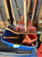 Group of tools in blue tub showing rakes, shears, small hand tools