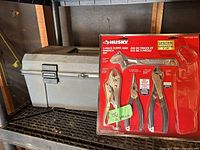 Toolbox on shelf next to sealed Husky 5-piece set