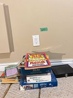 Stack showing Find-A-Word booklet atop Sequence and Dogs Dogs Dogs boxes