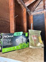 Boxed NOMA security light and packaged Estate Collection stake light