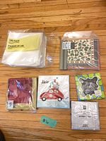 All items overview showing seven napkin packs and two grey taper candles