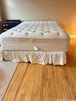 Queen mattress set with bed skirt on hardwood floor