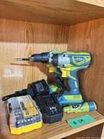 Radley impact driver, charger, battery and closed DeWalt bit case on shelf