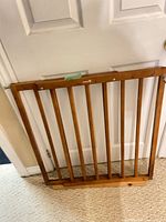 Front view of full wooden baby gate leaning against door