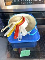 Nested strainers inside metal colander on blue lidded container