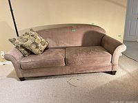 Front view of taupe microfiber loveseat with two pillows