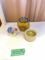 Group shot of all three main items: glass jar, porcelain figurine, ceramic votive with candle