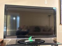Front view of Toshiba TV with remote on stand