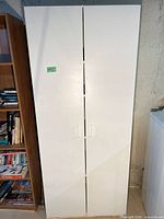 Front view of closed white laminate cabinet