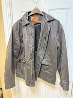 Front view of gray cotton jacket on hanger, lining visible