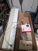 Boxed A9 camera, vanity light bar, coax splitter, wall plate, copper block and cables arranged in box