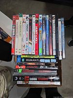 Stack of DVD/Blu-ray cases showing visible titles and spine condition