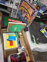 Battleship box, Scrabble board, open box with dice, tokens, dominoes