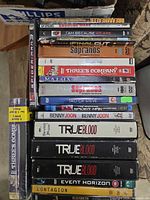 Stack of 16 DVD/Blu-ray cases showing titles listed