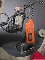 Both corded tools with cords visible, Ramset in foreground, Rockwell behind