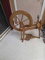 Full view of wooden Saxony spinning wheel showing wheel, treadle and frame
