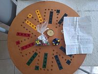 Top view of wooden Aggravation board with marbles, tin and instructions displayed