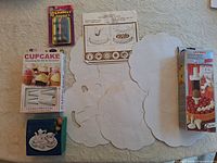 Top-down view of all boxed items, showing cake decorating kit, cupcake set, birthday candles, instruction sheet and paper doilies