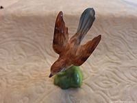 Front view of Staffordshire bird figurine showing brown wings and green base