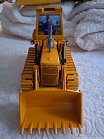 Front view of yellow Caterpillar 941 diecast track loader with bucket lowered
