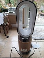 Front view of Dyson Hot+Cool unit showing copper perforated base, white loop, power cord