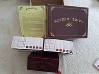 Closed maroon Golden Trivia box, instruction sheet, two inner card trays filled with trivia cards