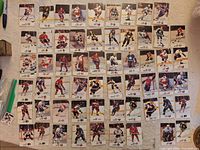 Overview of roughly 50 hockey cards arranged in grid, fronts visible