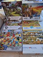 All six 300-piece puzzles boxed and upright for cover art view