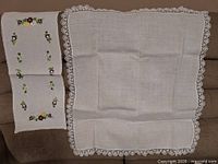 Runner with floral embroidery and plain cloth with crochet edging displayed
