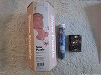 Packaging for three art-themed jigsaw puzzles: David Slow Puzzle box, Starry Night bottle puzzle, Vase of Flowers mini puzzle box