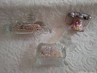 Three clear glass candy containers shaped as fire truck, telephone, Scottie dog