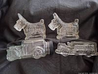 Front view showing two Scottie dog and two automobile glass containers