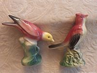 Front view of both ceramic bird figurines displaying colors and bases