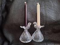 pair of clear glass bird-figural candle holders with two taper candles