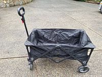 Overall view of folded-out black utility wagon on driveway