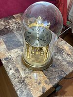 Clock under glass dome on table