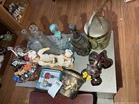Overview of lot on tabletop showing decanters, cherub stand, stoppers basket, ice bucket and bottle holder